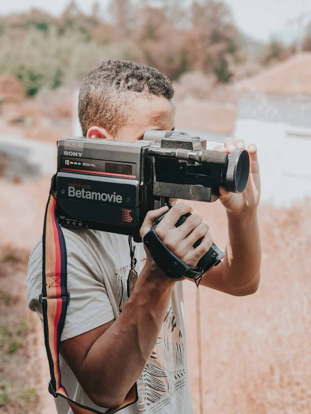 Camera operator filming with a vintage shoulder camera